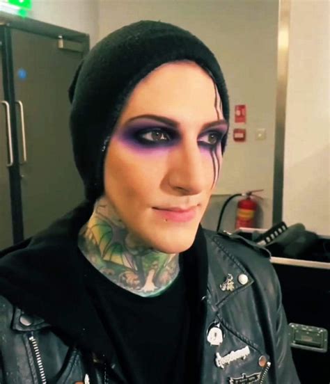 A Man With Tattoos And Piercings On His Face Wearing A Black Leather