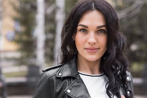 Beautiful Brunette Woman With Curly Hair Posing On The Street While