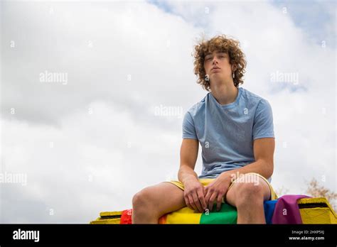 Gay Guy Posing Sitting On A Gay Pride Flag Stock Photo Alamy