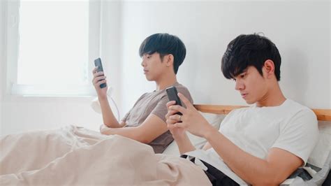 Casal Gay Asi Tico Usando Telefone Celular Em Casa Jovens Asi Ticos Lgbtq Homens Felizes
