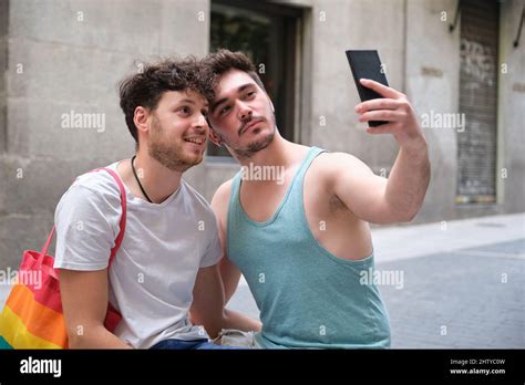 Gay Couple Taking A Selfie With The Smartphone Sitting In The Street Stock Photo Alamy