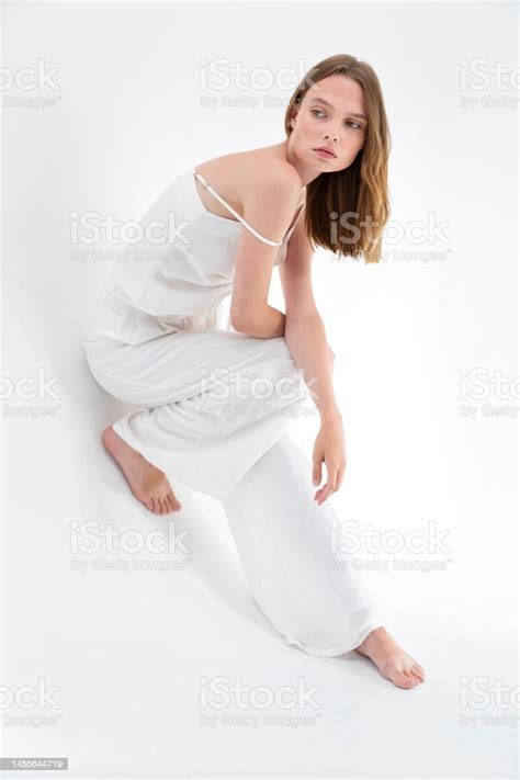 Blonde Freckled Girl On A White Background Wearing A Silk Or Linen