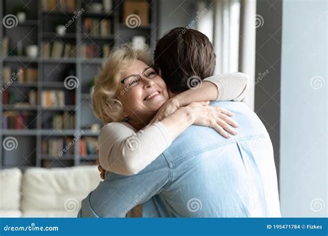 Close Up Smiling Mature Woman Wearing Glasses Hugging Adult Son Stock
