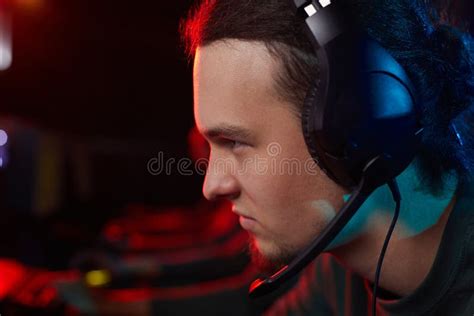 Serious Gamer Sitting At Computer Watching A Game On Gradient Ba Stock