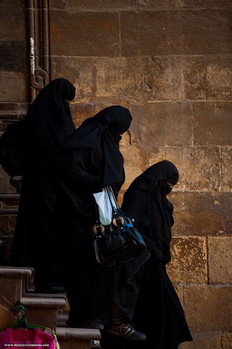 covered cairenes muslim women  burqas navigate  set  stairs