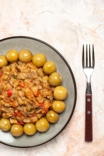 Free Photo Top View Of Roasted Eggplant Salad And Pickled Plums On Plate On Nude Surface