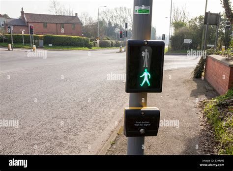 Green man light showing on a pedestrian pelican crossing panel on a