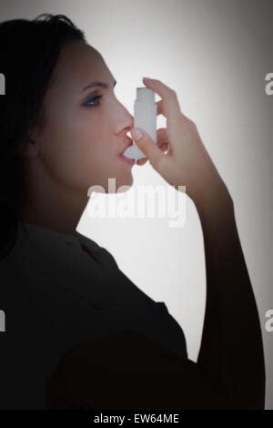 Composite Image Of Asthmatic Brunette Using Her Inhaler Stock Photo Alamy