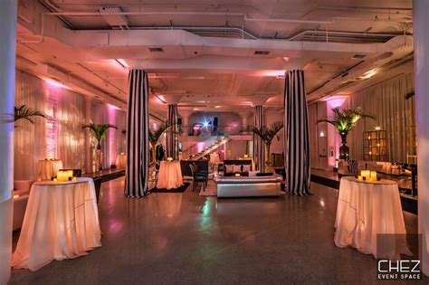 Modern Event Space With Tall Cocktail Tables And White Linens Metallic Curtains Glass Bar Area