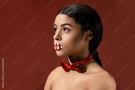 Beautiful Naked African American Woman With Red Bow Tie And Creative Makeup Looking Away