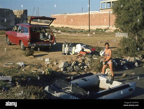 A Woman In A Bikini Loads A Rubber Boat For A Diving Trip On The Greek Island Of Naxos In The