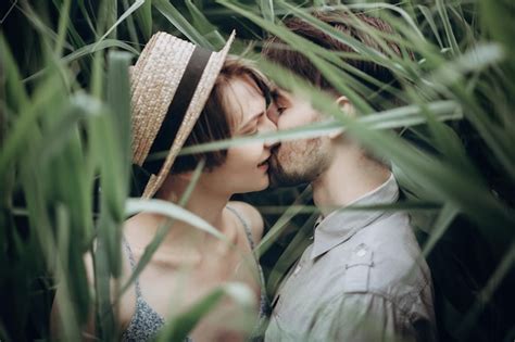 Pareja hipster abrazándose en bastón en el lago en el parque de verano