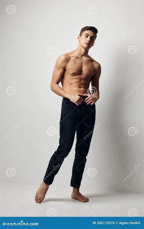 A Man In Jeans Stands On The Floor In A Room With A Naked Torso In Full