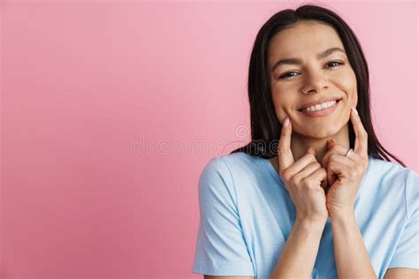 Brunette Hispanic Woman Smiling And Pointing Fingers At Her Cheeks