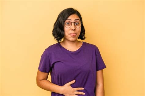 Jovem Mulher Latina Isolada Em Fundo Amarelo Toca A Barriga Sorri Suavemente Comendo E