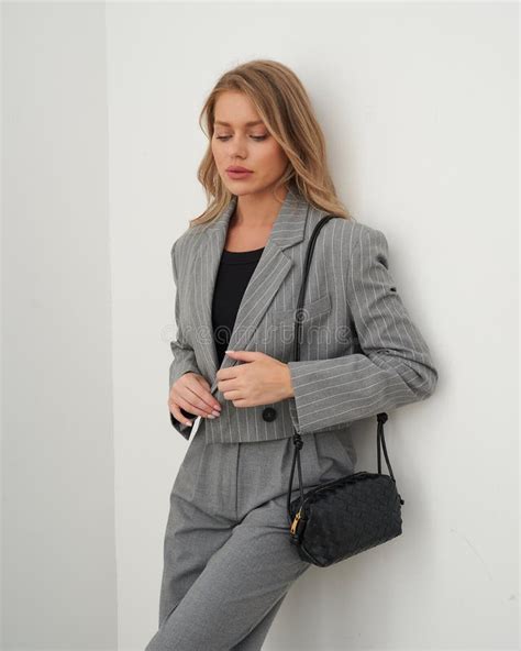Blonde Woman In Grey Striped Blazer And Trousers Posing Stylishly Indoors Stock Image Image Of