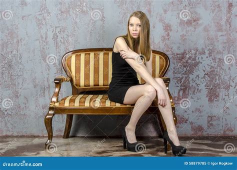 Belle Jeune Femme Blonde Aux Cheveux Longs Avec Un Chiffre Mince Dans Une Mini Robe Noire Image