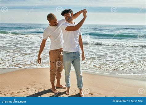 Jovem Casal Gay Sorrindo Feliz Dançando Na Praia Imagem de Stock Imagem de exterior sorriso