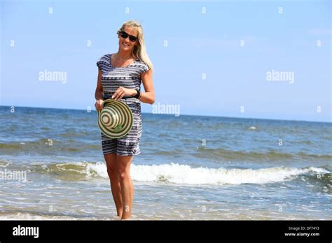 Full Length Mature Woman With Hat On Beach Enjoying Summer Holiday Stock Photo Alamy