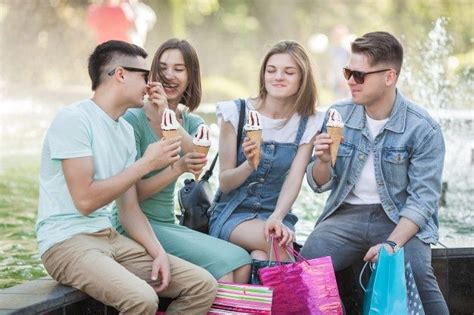 Grupo de jóvenes alegres comiendo helado Premium Photo Freepik