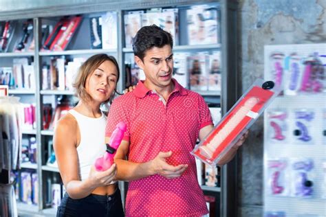 Compradores Hombres Y Mujeres Tocando El Gran Dildo En La Tienda De Sexo Moderna Imagen De