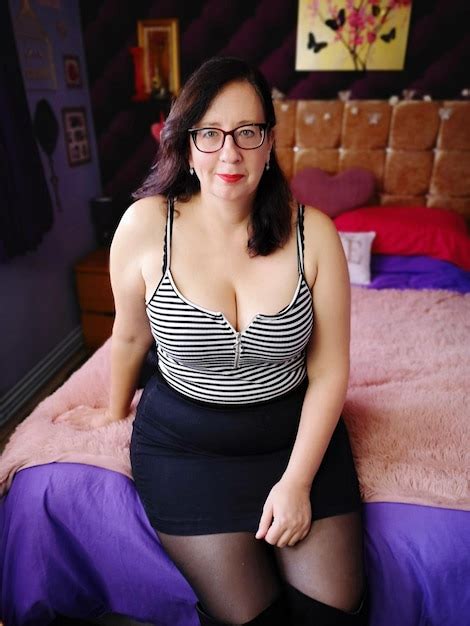 Premium Photo Portrait Of Seductive Mature Woman Sitting On Bed At Home