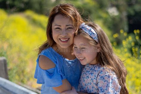 M E E Filha De Latina Que Sorriem E Que Riem Em Um Monte Na Frente Das Flores Amarelas Foto De