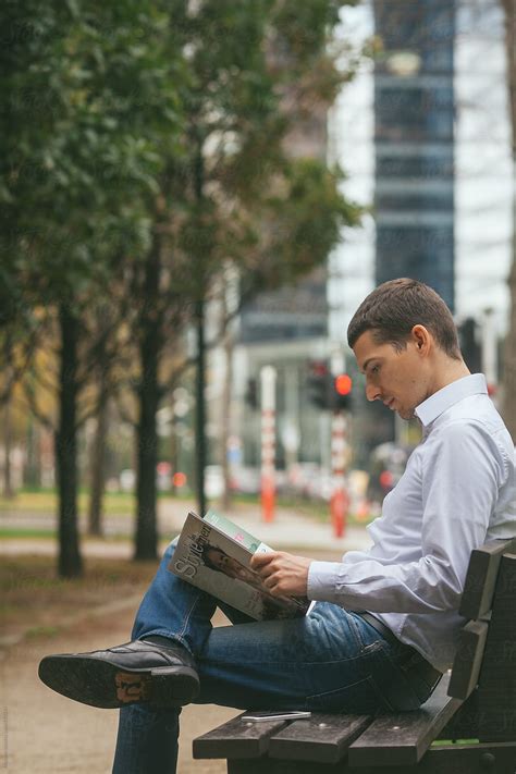 Man Reading A Magazine In The Park By Stocksy Contributor Mosuno