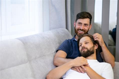 Premium Photo Smiling Attractive Gay Hugs His Soul Mate In The Living Room Of His House Lying