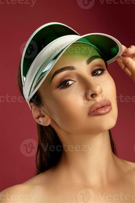 Close Up Portrait Of A Brunette Nude Model Girl In A Green Visor With Professional Evening Make