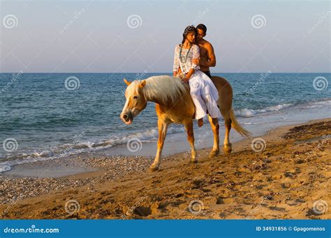 Attractive Couple In Love Riding Horse On The Beach Royalty Free Stock