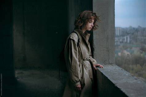 A Girl Stands An Icon In A Coat In An Abandoned Building In Flowing Hair By Stocksy