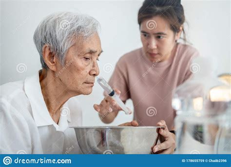 Asian Daughter Making Nasal Washnose Cleaning With Syringe And Saline