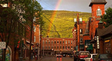 A Rainbow Shines In The Sky Over A City Street