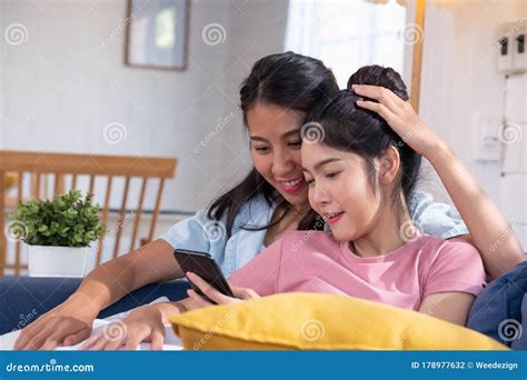 Asian Lesbian Couple Kissing Their Adopted Baby On Both Cheecks Royalty Free Stock Photo