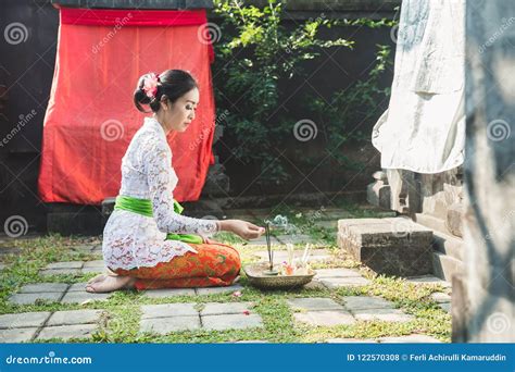 Balinese Woman Praying At Temple On Small Shrines In Houses Stock Photo