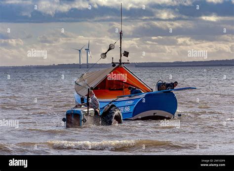 Tradditional Coble Fishing Boat Being Hauled Out Of The Sea After A