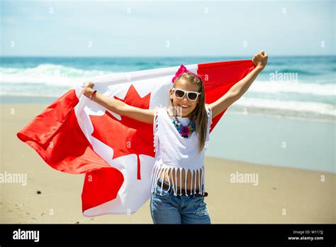 Happy Canadian Girl Carries Fluttering White Red Flag Of Canada Against