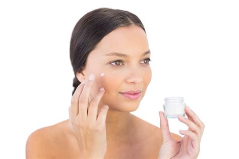 Premium Photo Brunette Woman Spreading Beauty Cream On Her Cheek