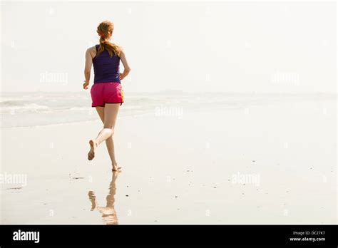 Mature Woman Jogging On Beach Stock Photo Alamy