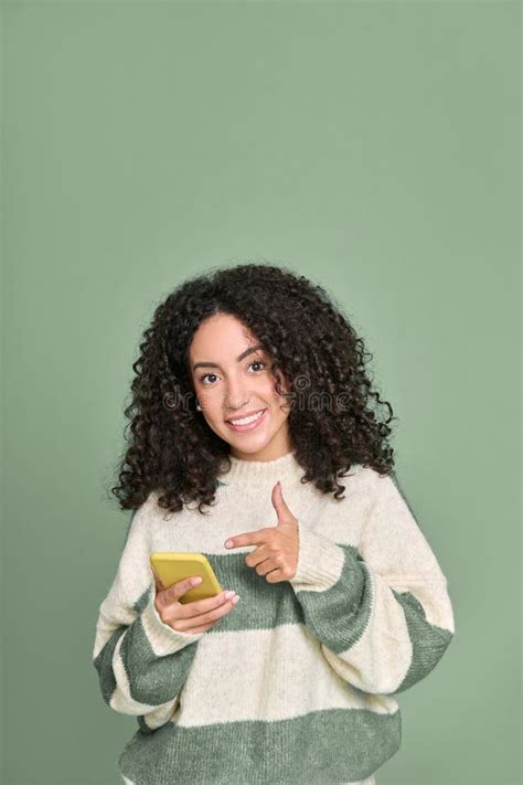 Jovem Feliz Latina Apontando Para O Telefone Celular Isolada Em Verde Imagem De Stock Imagem