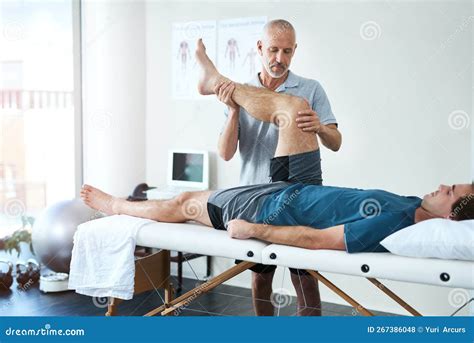 Tell Me When You Start Feeling The Discomfort A Handsome Mature Male Physiotherapist Treating A