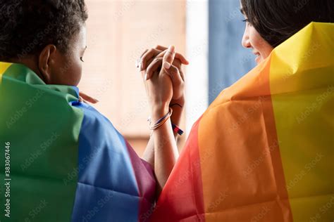 Black African LGBT Woman Covering LGBTQ Rainbow Flag With Asian LGBT Woman Upside Down Gay
