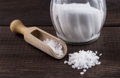 Salt With Wooden Spoon And Glass Saltshaker On Wooden Table Stock Photo