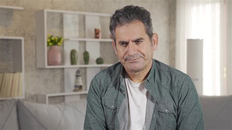 Close Up Shot Of Thoughtful Mature Adult Man With Gray Hair Sitting Alone At Home Thinking About