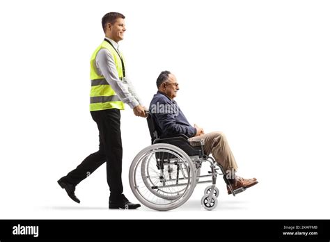 Full Length Profile Shot Of An Airport Support Worker Pushing A Mature