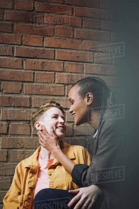 Romantic Gay Couple Looking At Each Other By Brick Wall Stock Photo Dissolve