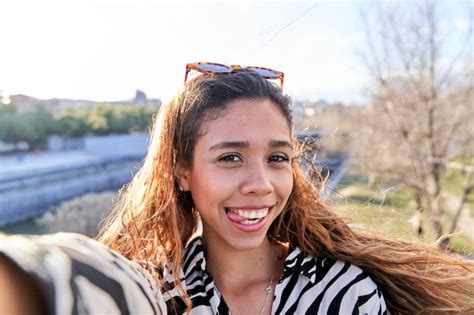 Premium Photo Portrait Of A Latina Woman Taking A Selfie With Her Smartphone While Making A