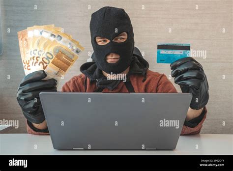 Happy cybercriminal man holding euro cash and stolen credit card ...