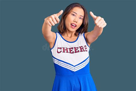 Young Beautiful Chinese Girl Wearing Cheerleader Uniform Approving